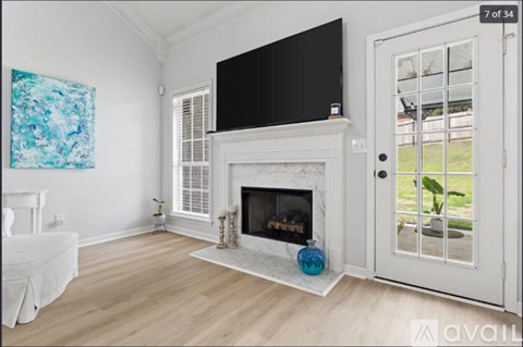 A living room with a fireplace and a television mounted above it.