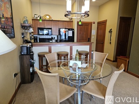 A kitchen with a table and chairs in the foreground.