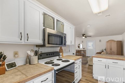 A kitchen with white cabinets and a black stove top.