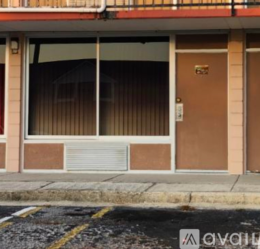 A brown door with a sign on it is on a building.