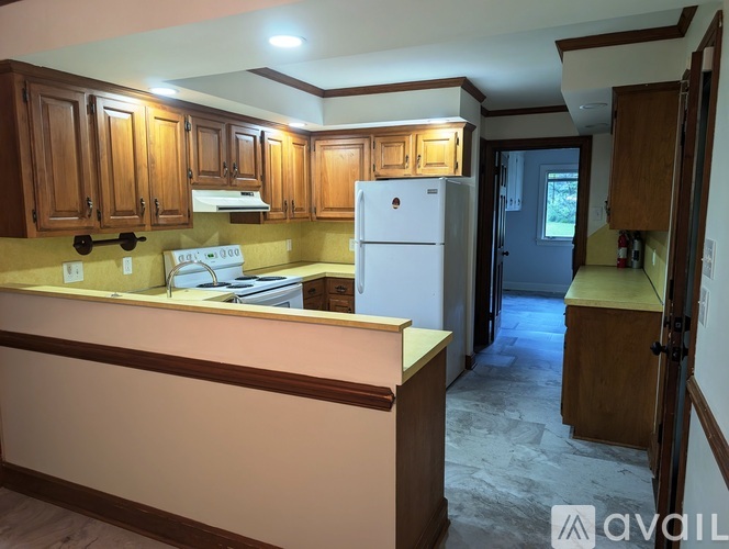 A kitchen with wooden cabinets and a white fridge.