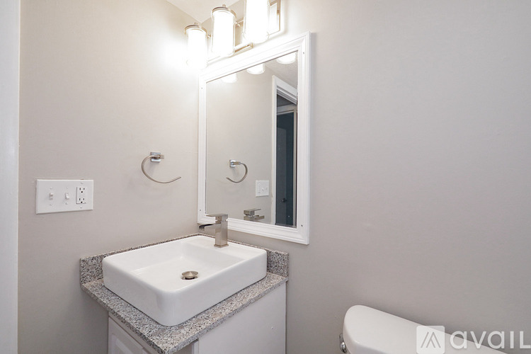 A bathroom with a sink, mirror, and toilet.