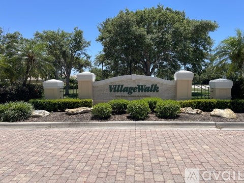 A brick walkway leads to a sign that says Village Walk.