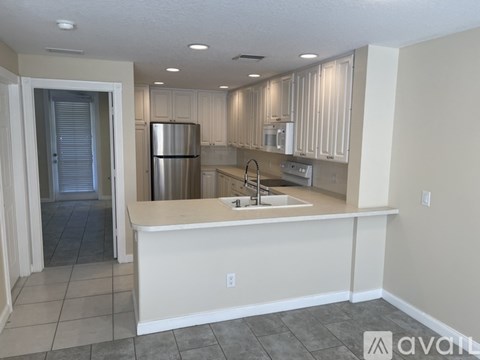 A kitchen with white cabinets and a stainless steel refrigerator.