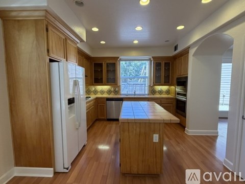 A kitchen with wooden cabinets and a white refrigerator.