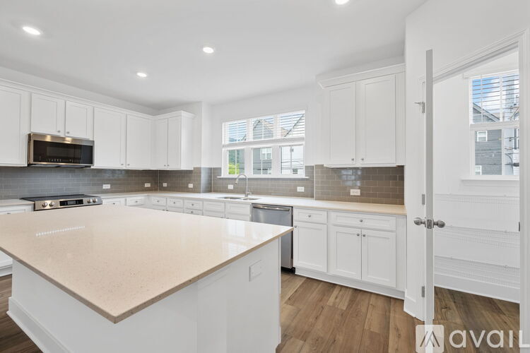 A kitchen with white cabinets and a beige countertop.
