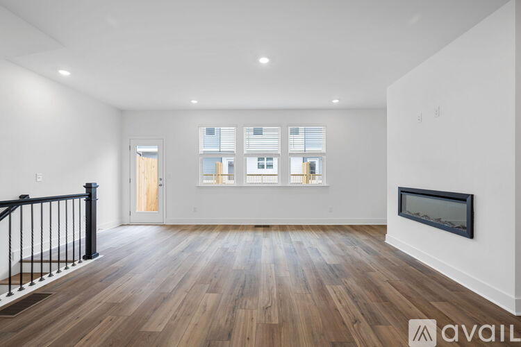 A spacious living room with a fireplace and hardwood floors.