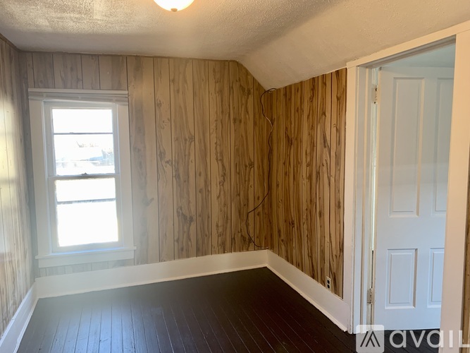 A room with wooden walls and a white door.