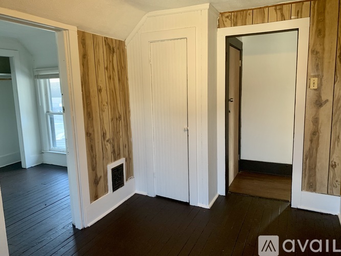 A room with wooden walls and a white door.