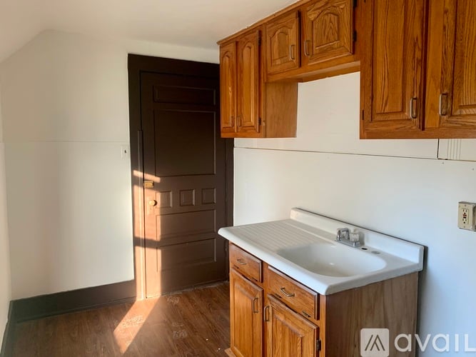 A kitchen with wooden cabinets and a white sink.