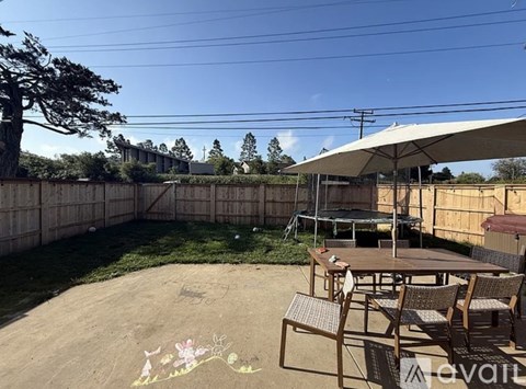 A backyard with a patio table and chairs.