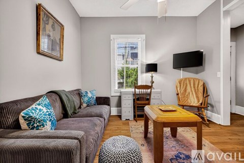 A living room with a brown couch and a wooden coffee table.