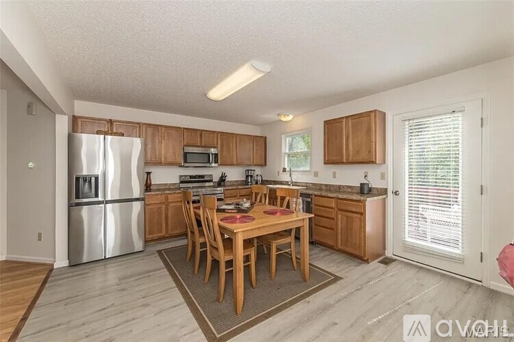 A kitchen with a table and chairs in the middle of the room.