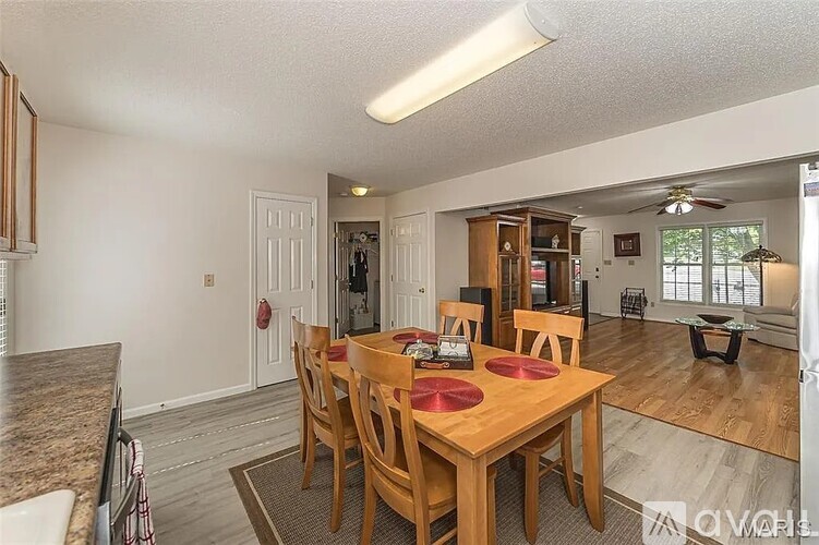 A dining room with a wooden table and chairs.