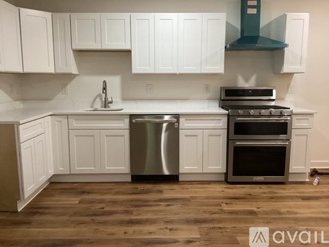 A kitchen with white cabinets and a stainless steel dishwasher and oven.
