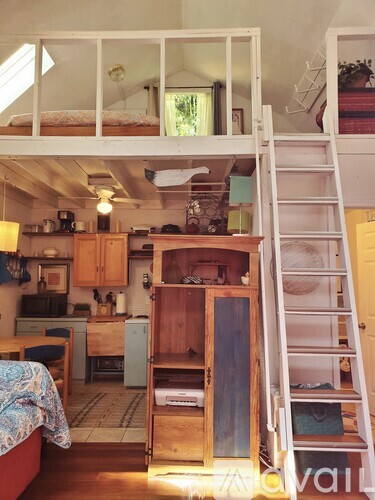 A small room with a bed and a kitchen area.