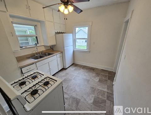 A kitchen with a white stove and a fan.