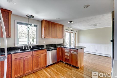 A kitchen with wooden cabinets and a black countertop.