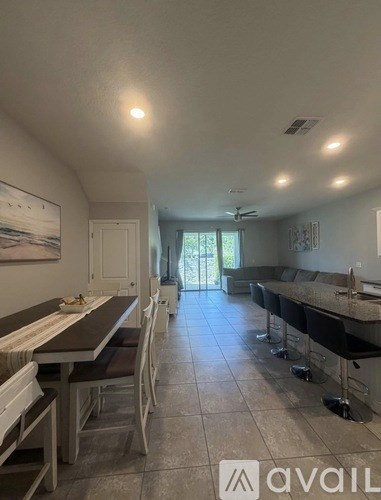 A kitchen with a dining table and chairs.