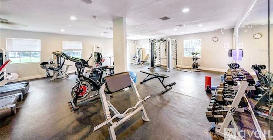 A gym with a variety of exercise equipment including treadmills, stationary bikes, and weight machines.