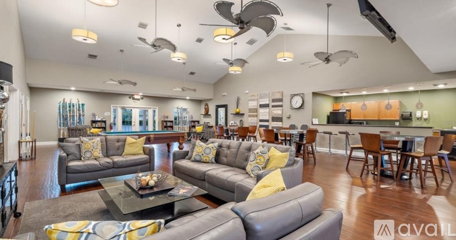 A living room with a grey couch and yellow pillows.