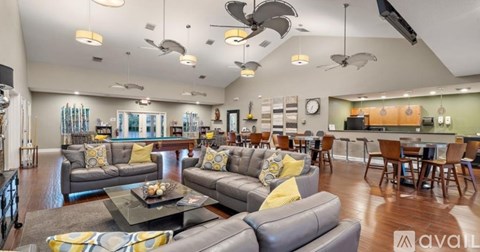 A living room with a grey couch and yellow pillows.
