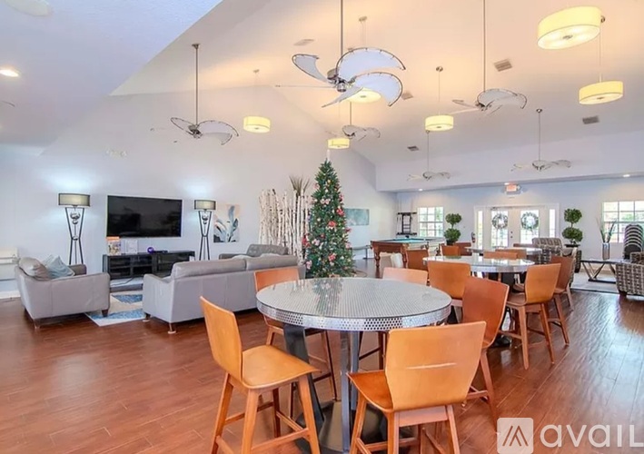 A Christmas tree is in the middle of a dining room.