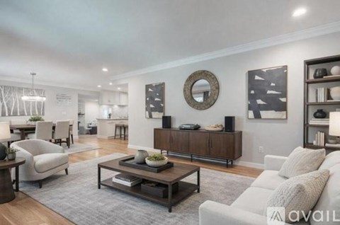 A modern living room with a grey rug and a white sofa.