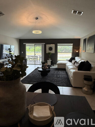 A living room with a couch, coffee table, and a large vase.