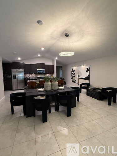 A modern kitchen with a dining table set for two.