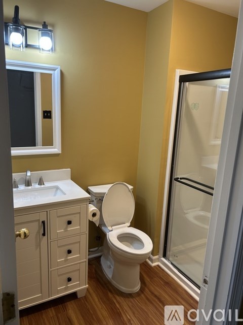 A bathroom with a toilet, sink, and mirror.