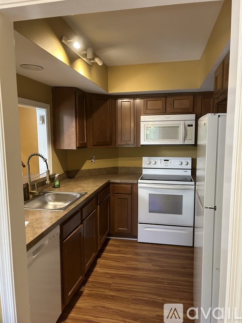 A kitchen with wooden cabinets and white appliances.