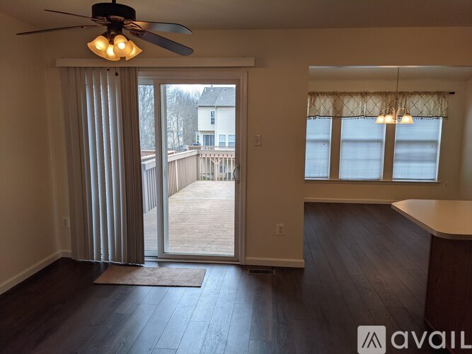 A room with a ceiling fan and a view of a deck outside.