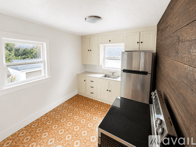 A kitchen with a stove top oven and a refrigerator.