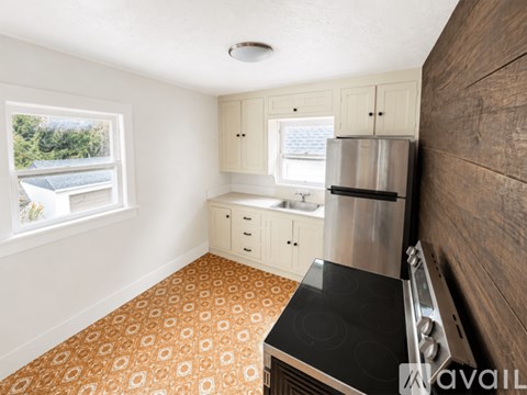 A kitchen with a stove top oven and a refrigerator.