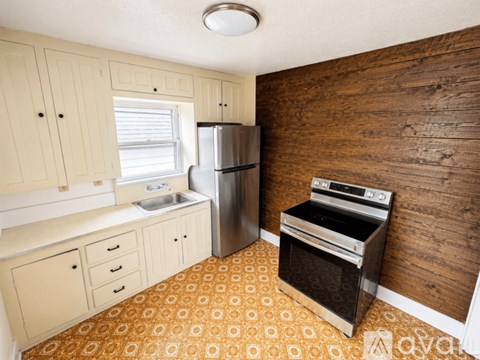 A kitchen with wooden walls and a stove top oven.