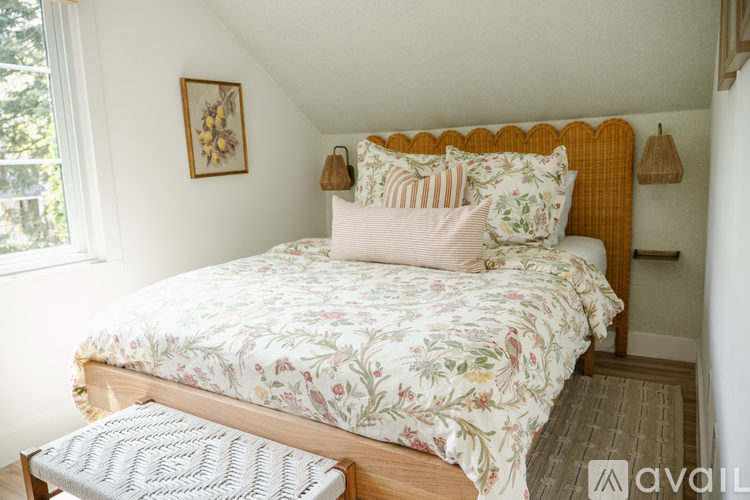 A bed with a floral comforter and a wooden headboard.