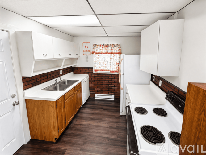 A kitchen with a stove, sink, and cabinets.