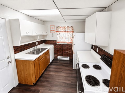 A kitchen with a stove, sink, and cabinets.