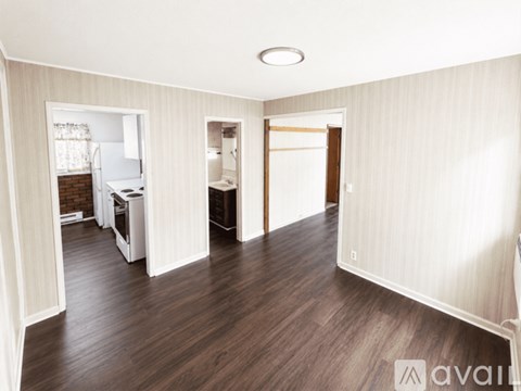A spacious room with wooden floors and white walls.