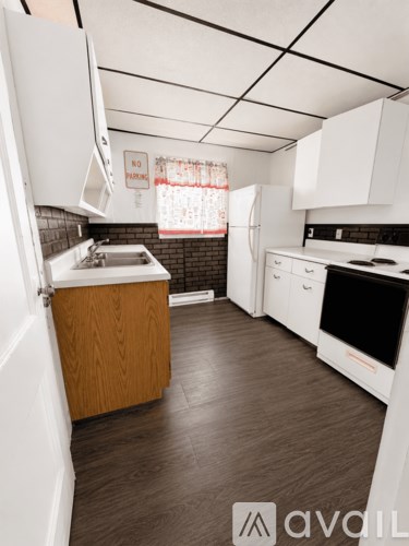 A kitchen with white cabinets and a wooden island.
