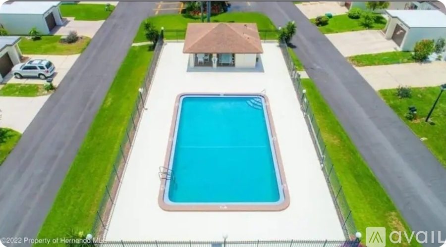 A swimming pool in a backyard surrounded by a fence.