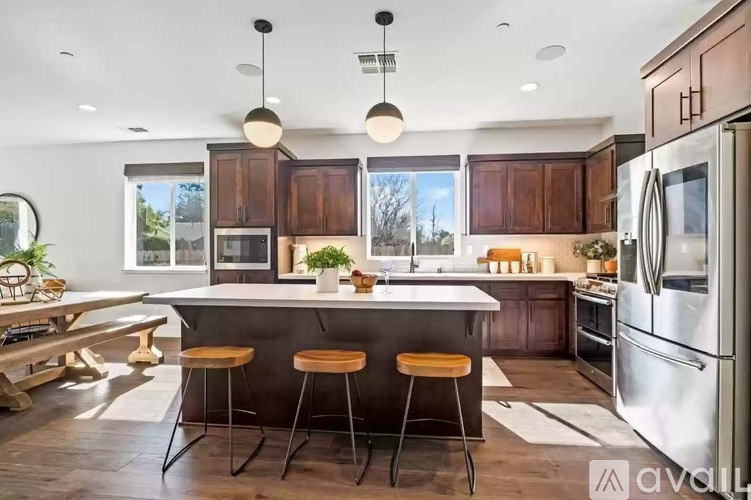 A kitchen with a center island and bar stools.