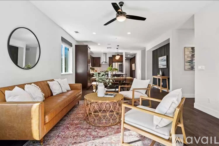 A living room with a brown couch, a chair, and a table with a plant on it.
