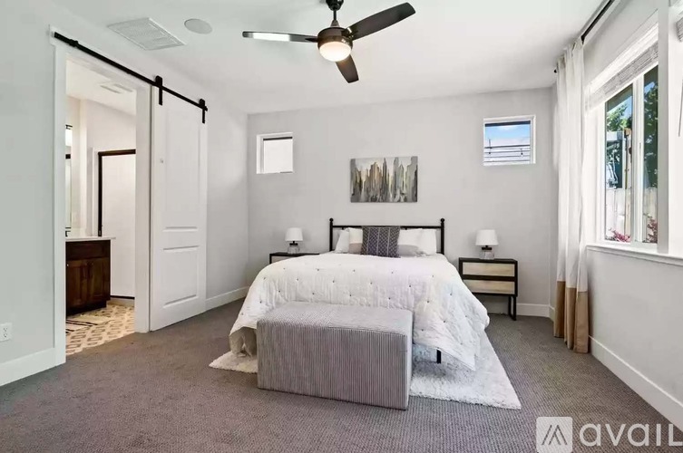 A bedroom with a large bed and a ceiling fan.
