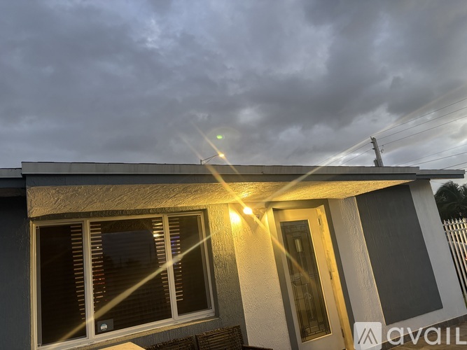 A house with a grey roof and a sign that says "AVAILABLE" on the side.