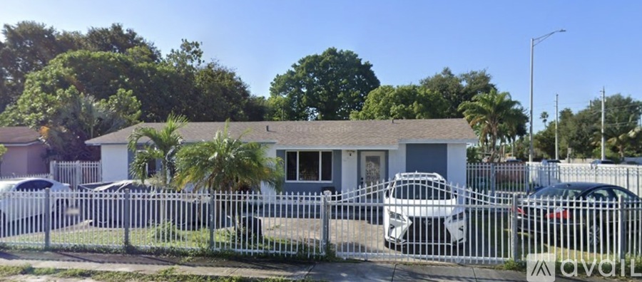 A small house with a white fence in front of it.