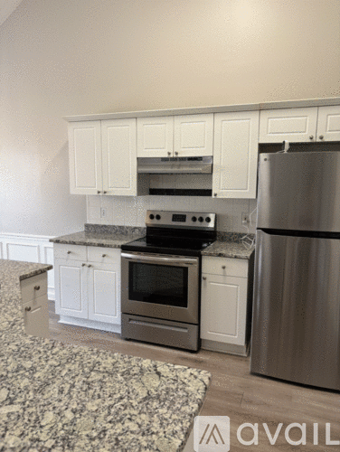 A kitchen with white cabinets and a granite countertop.