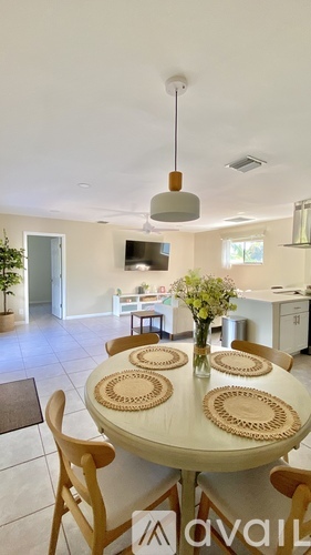 A dining room with a round table and chairs.