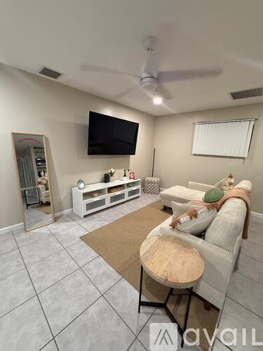 A living room with a couch, a coffee table, and a television.
